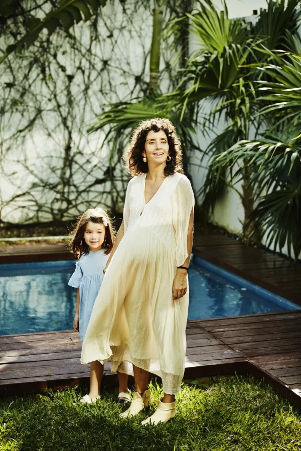 A woman with a young girl in front of a pool