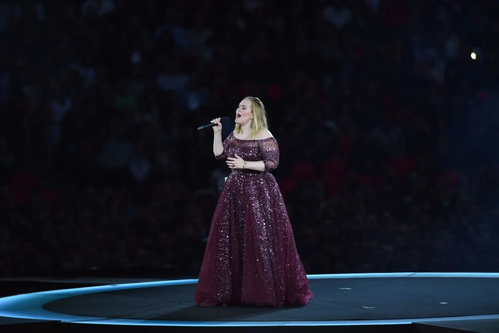 Adele performing on stage at the Wembley Stadium