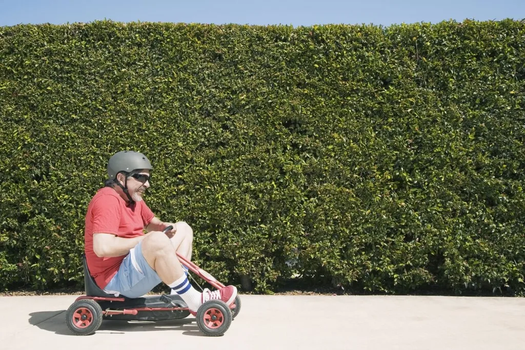 An old man on a child's red go-kart