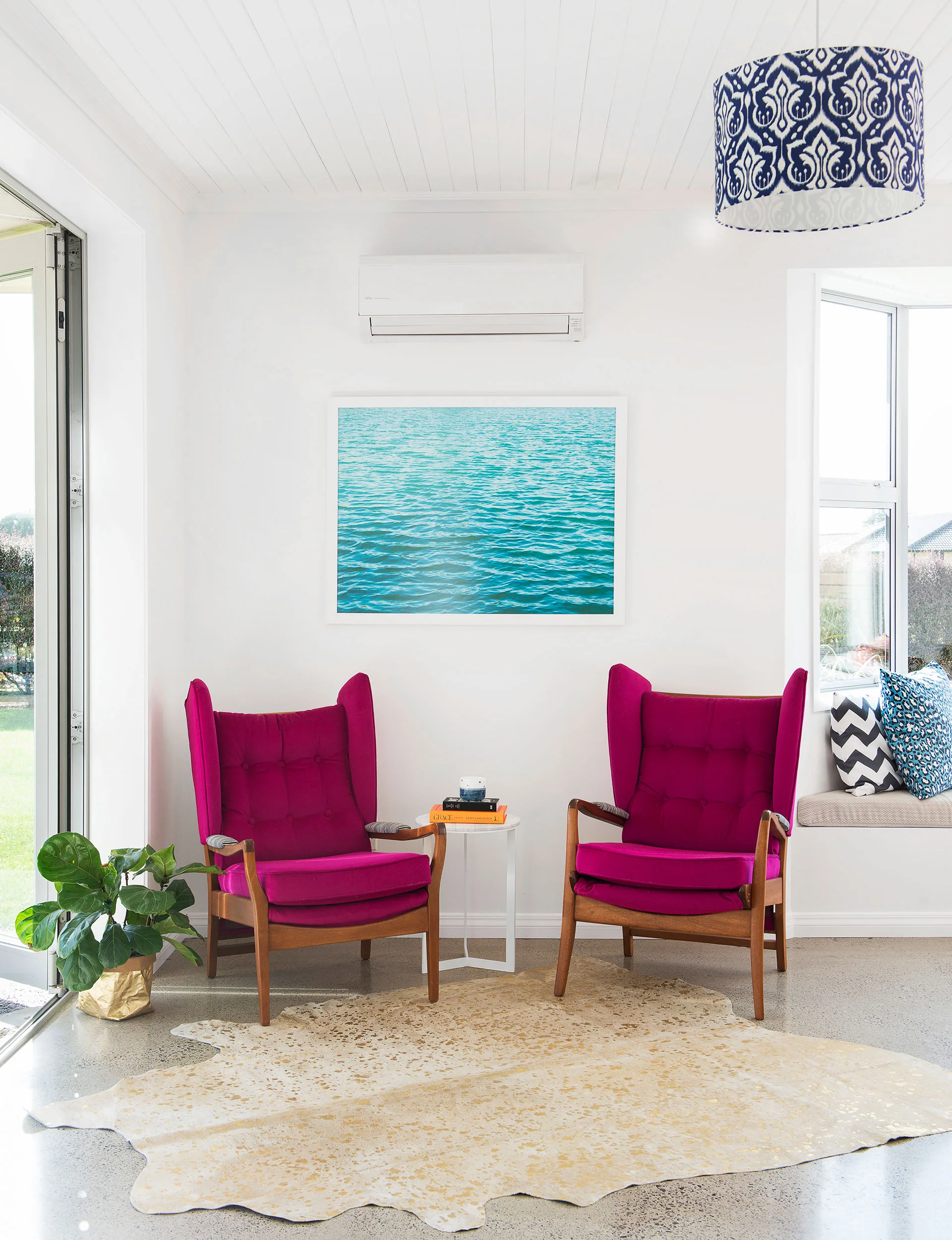 Two pink reupholstered antique chairs are a great place to sit with a friend and have a glass of wine.