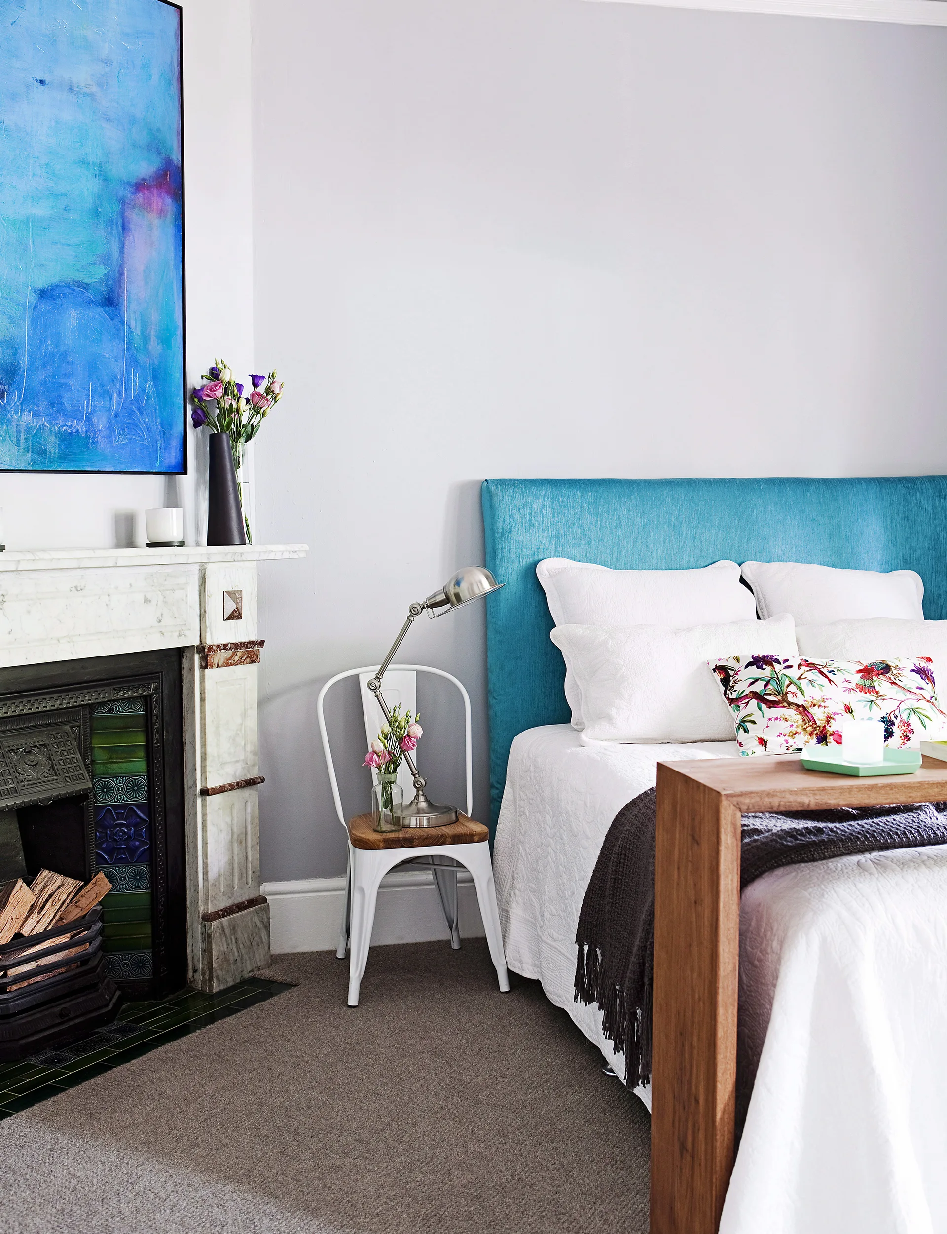 The turquoise hues of the bedhead and artwork by Andrew O’Brien are a focal point of the bedroom. They pop against the backdrop of grey and white.