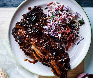 Sticky barbecue beef ribs with coleslaw and soft onion rolls