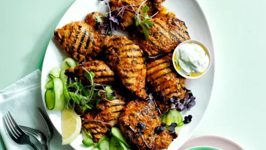 Chicken souvlaki is one of our favourite Greek recipes. Her eit is served on a plate with green garnishes, lemon wedge and small bowl of tzatziki