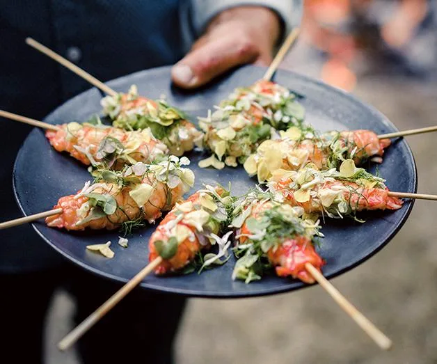 Grilled marron on a stick with citrus butter, flowers and herbs