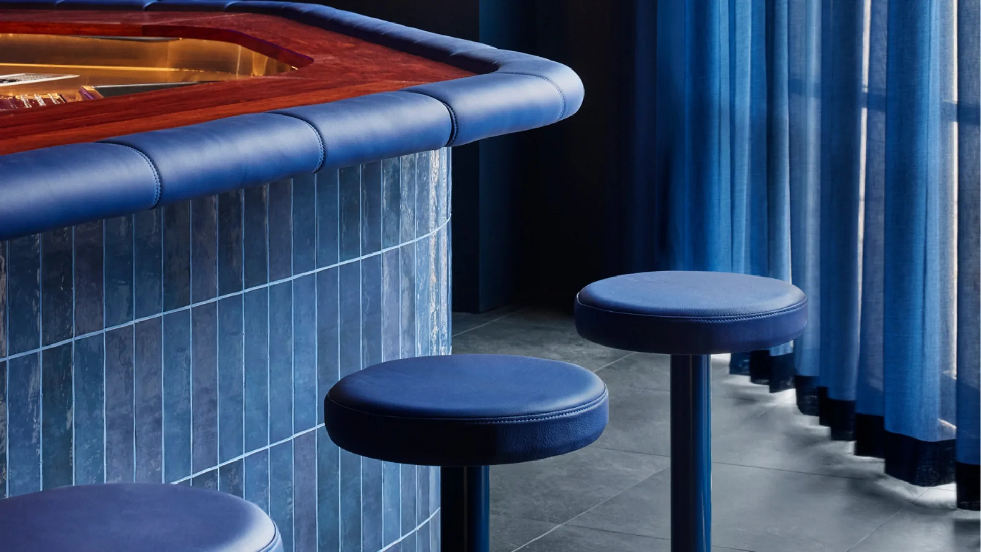 A close-up shot of the indigo-blue stools, curtain and tiling of Brisbane's +81 Aizome Bar. 