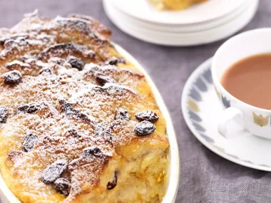 Classic bread and butter pudding, served with a cup of tea for traditional British comfort.