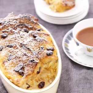 Classic bread and butter pudding, served with a cup of tea for traditional British comfort.