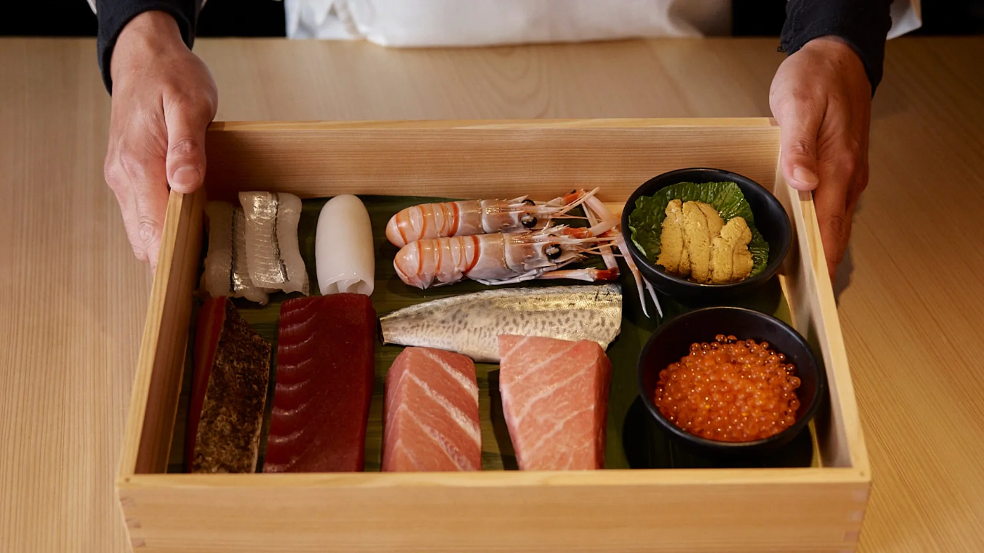 A wooden tray displaying cuts of raw fish, skilfully prepared by the chefs at Sushi Room, Brisbane.