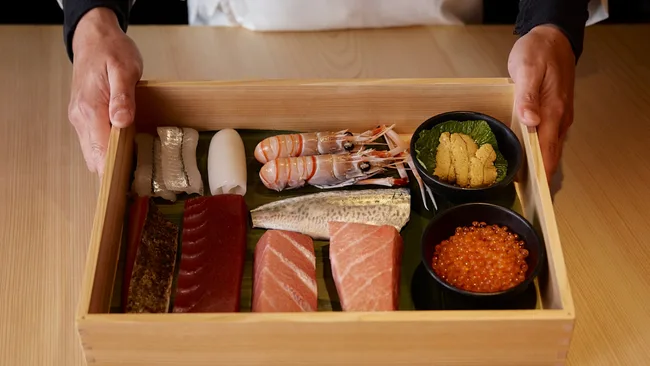 A wooden tray displaying cuts of raw fish, skilfully prepared by the chefs at Sushi Room, Brisbane.