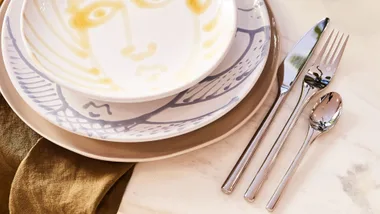 knife, fork and spoon laid beside a plate and bowl