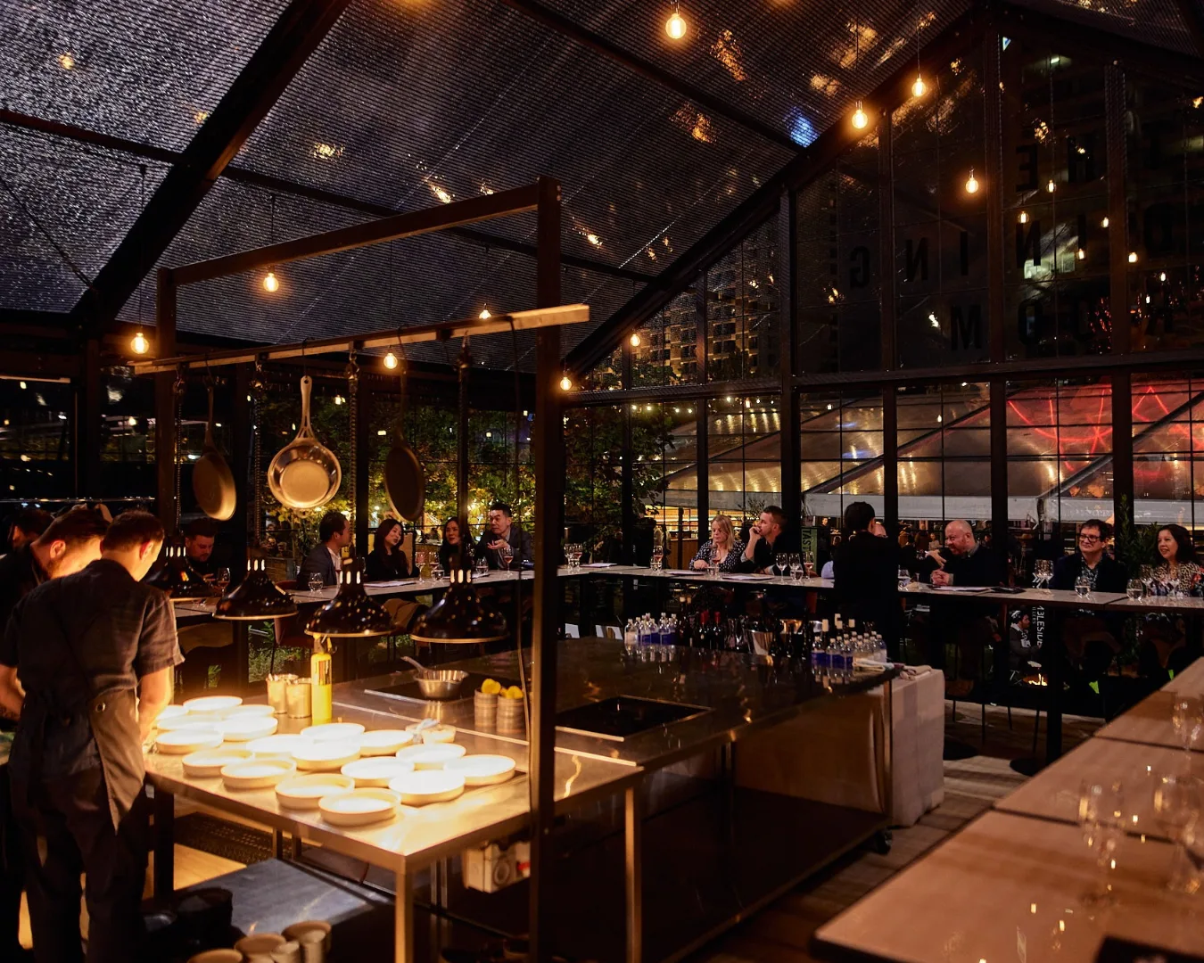 A pop-up restaurant with counter seating and festoon lights at Tasting Australia