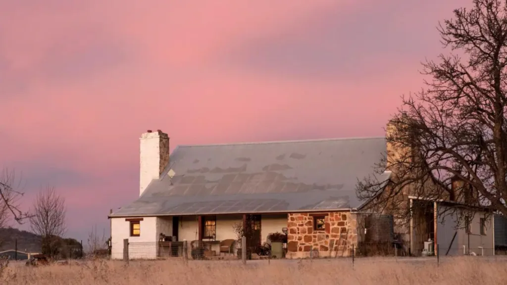 Jindayne Airbnb cottage exterior at dusk with pink sky