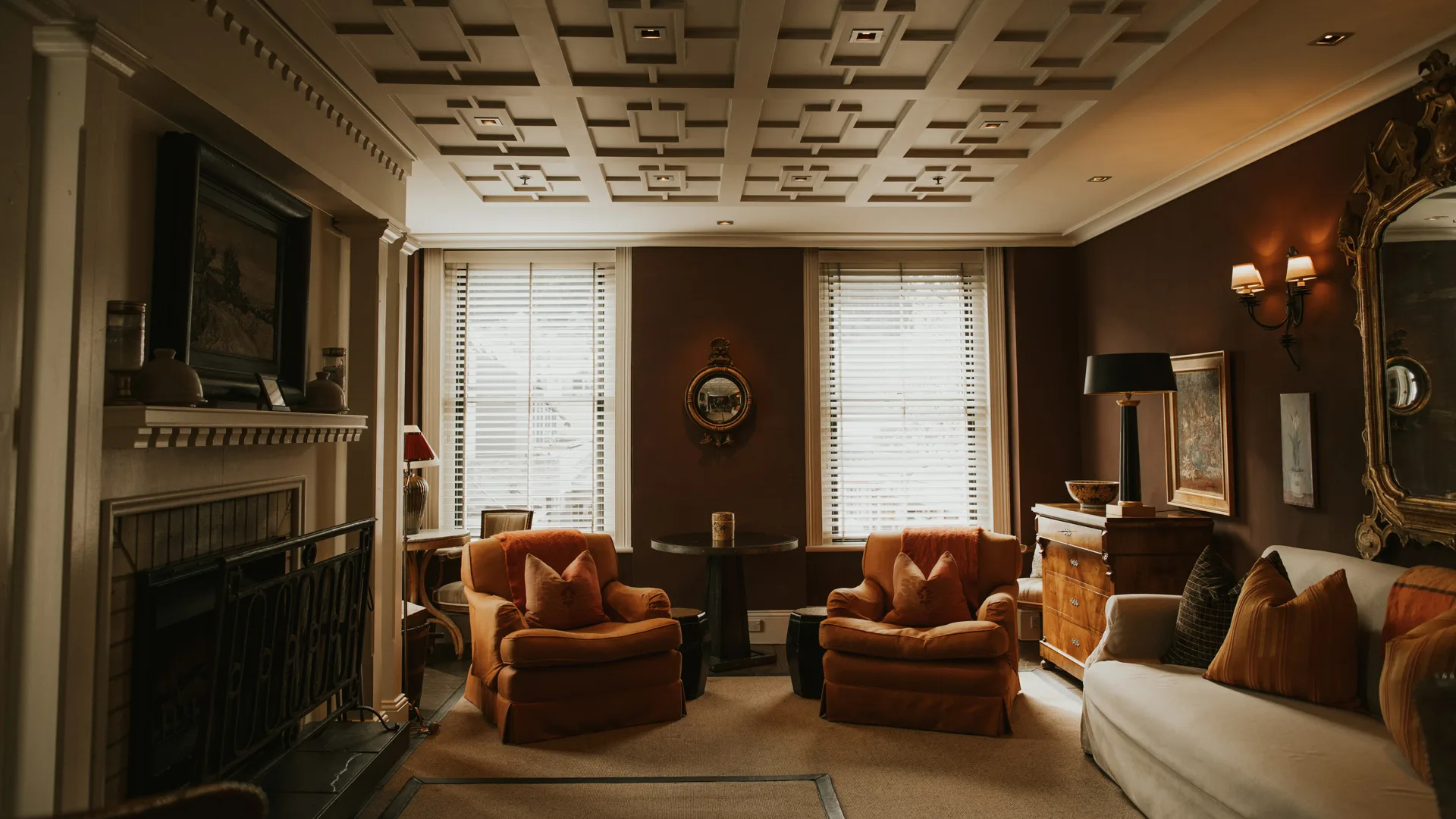 Two orange arm chairs in a cosy looking room at Queenstown hotel, Eichardt's Private Hotel New Zealand