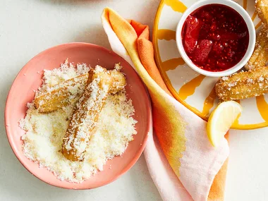 Lemon sugar churros with mixed berry compote on terracotta bowls.