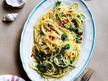 Linguine with lemon chilli and parmesan on white and blue serving platter.