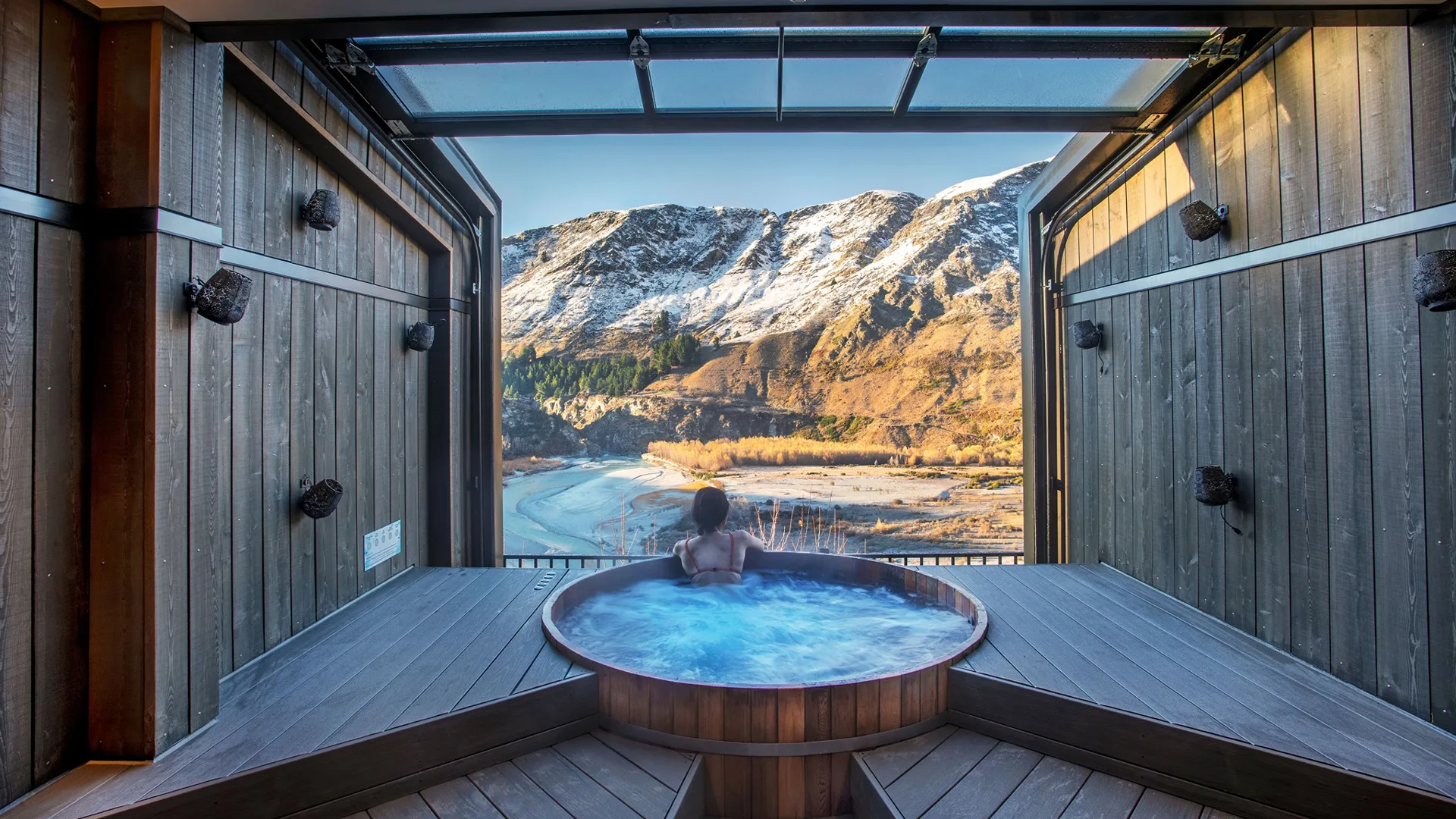Person soaking at Onsen Hot Pools with mountainous views in Queenstown New Zealand.