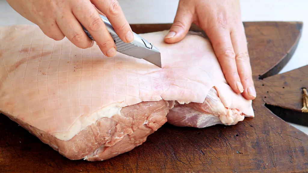 Porchetta skin is scored to ensure an even crackling.