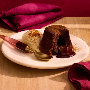 Chilli and chocolate lava cake on plate with spoon and red napkins.