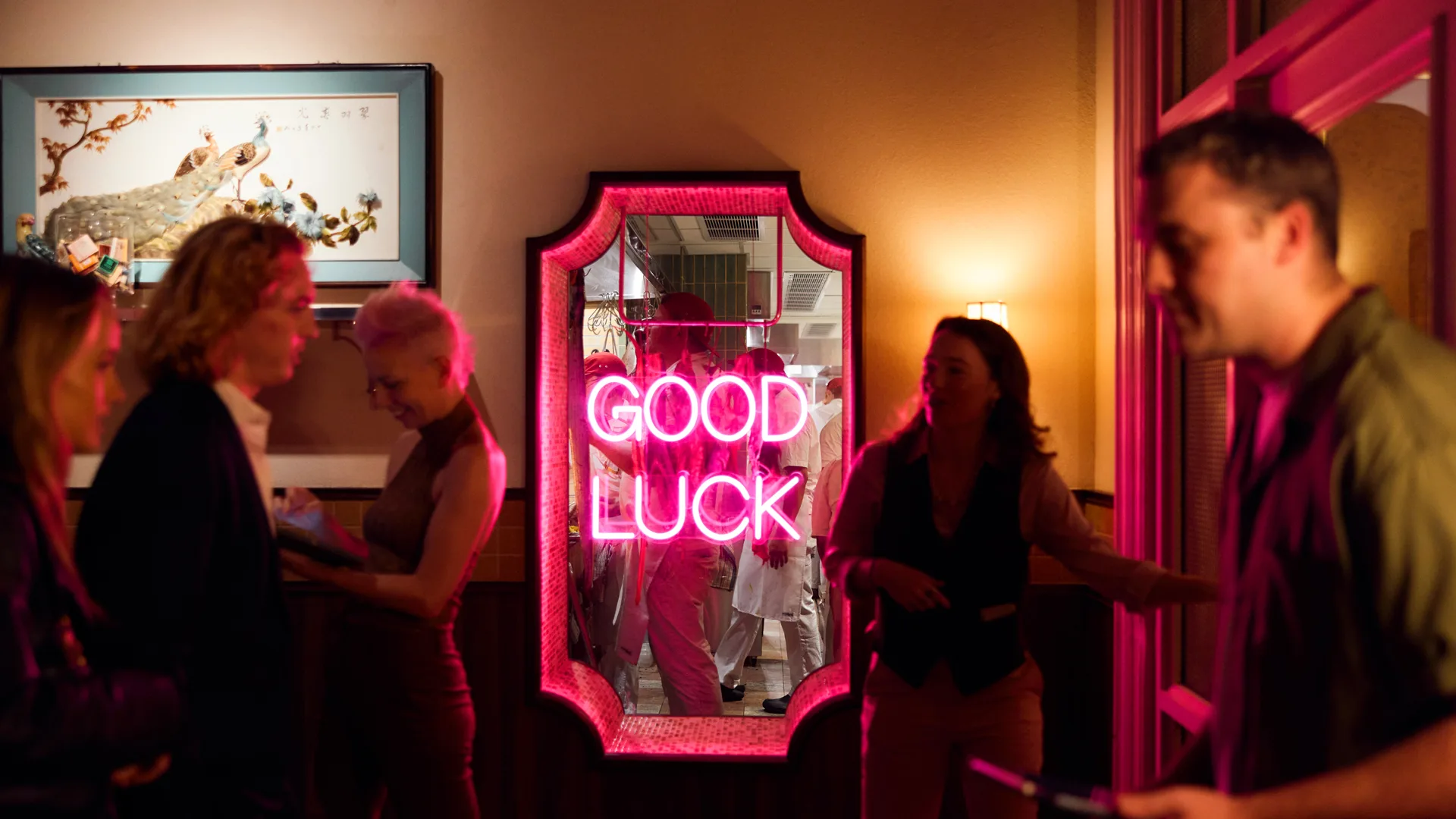 People at restaurant with neon pink sign reading "Good Luck" in middle at Merivale's Good Luck Restaurant Lounge in Sydney CBD
