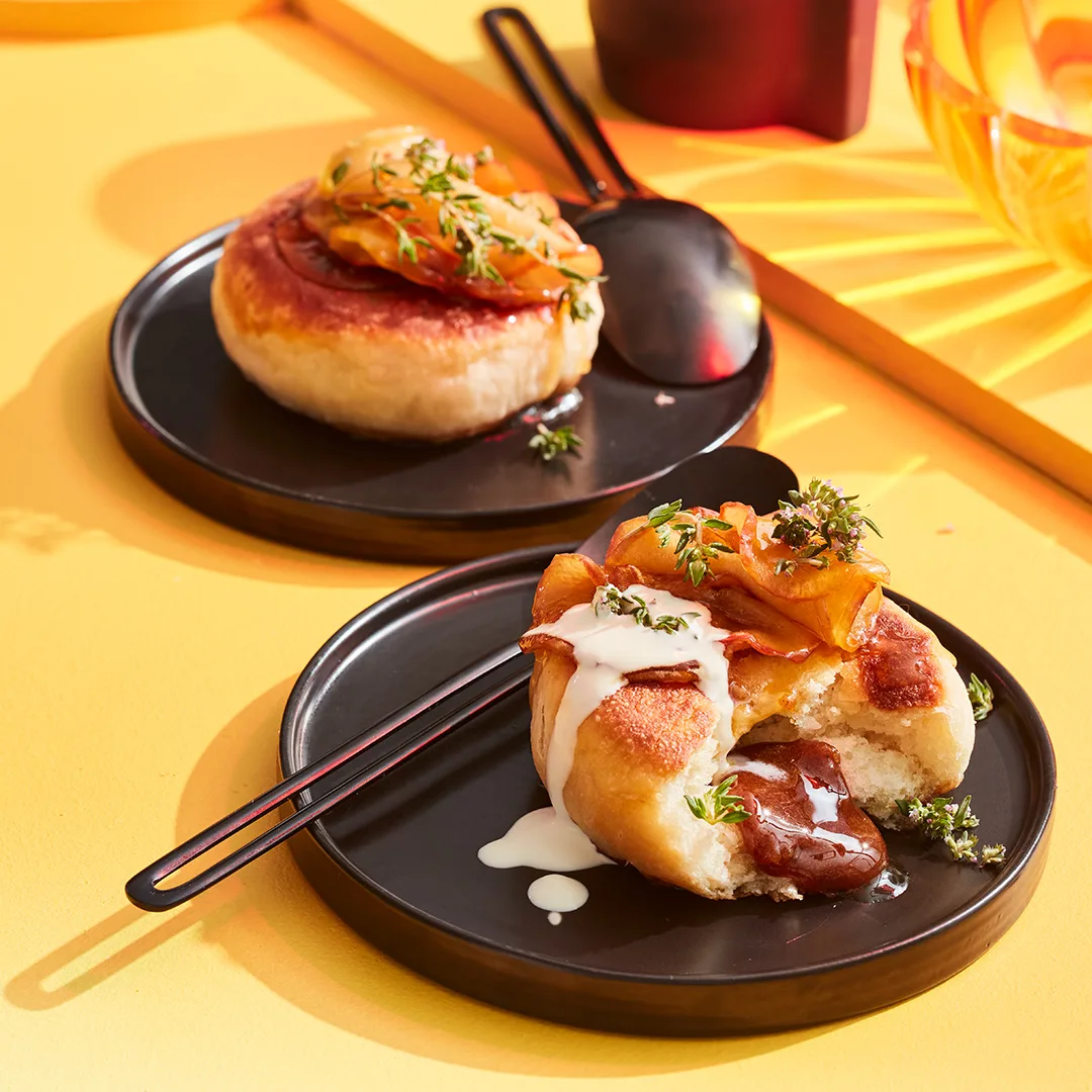 Korean fried doughnuts on black plate with yellow background.
