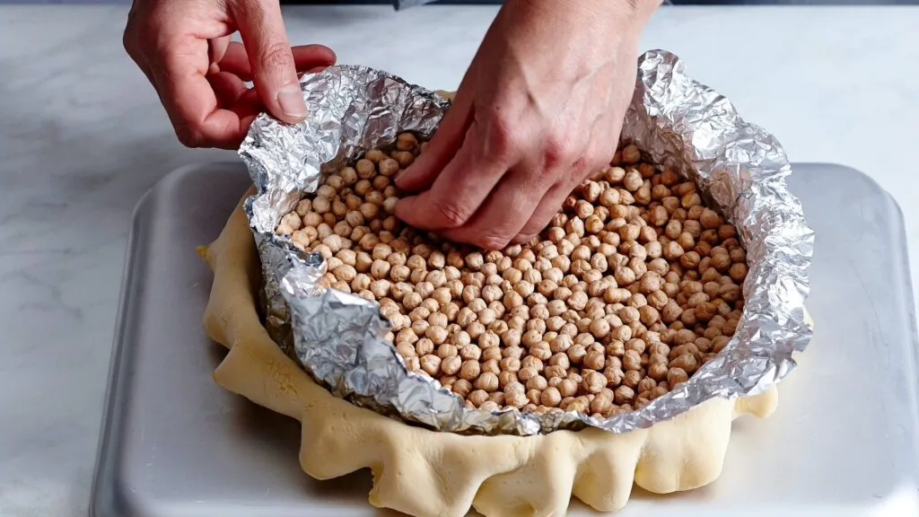 Baking weights help pastry cook evenly for a perfect base to this lemon tart.