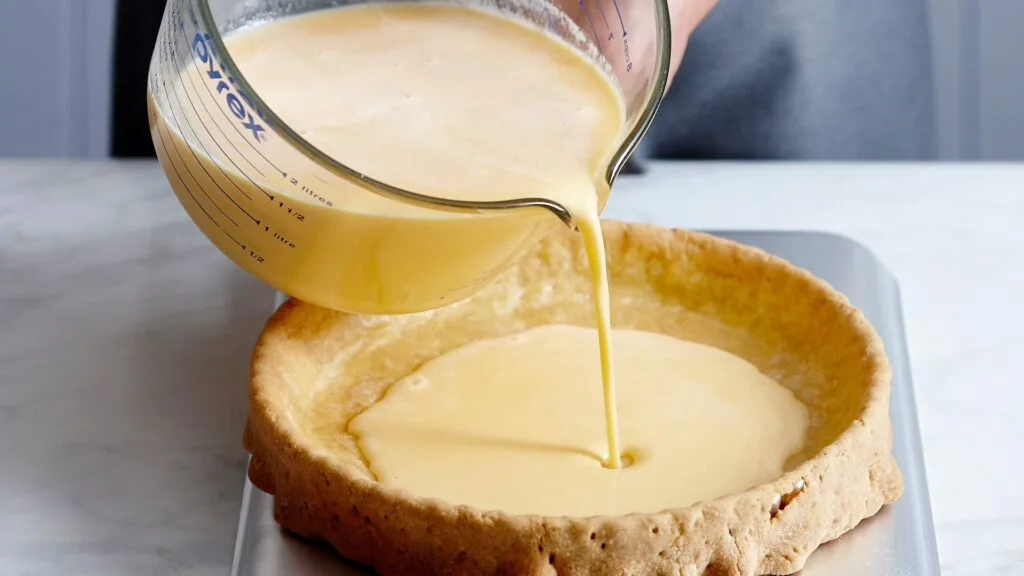 Filling a lemon tart is easier if you only pour half the custard in before transferring it to the oven rack and topping it up.