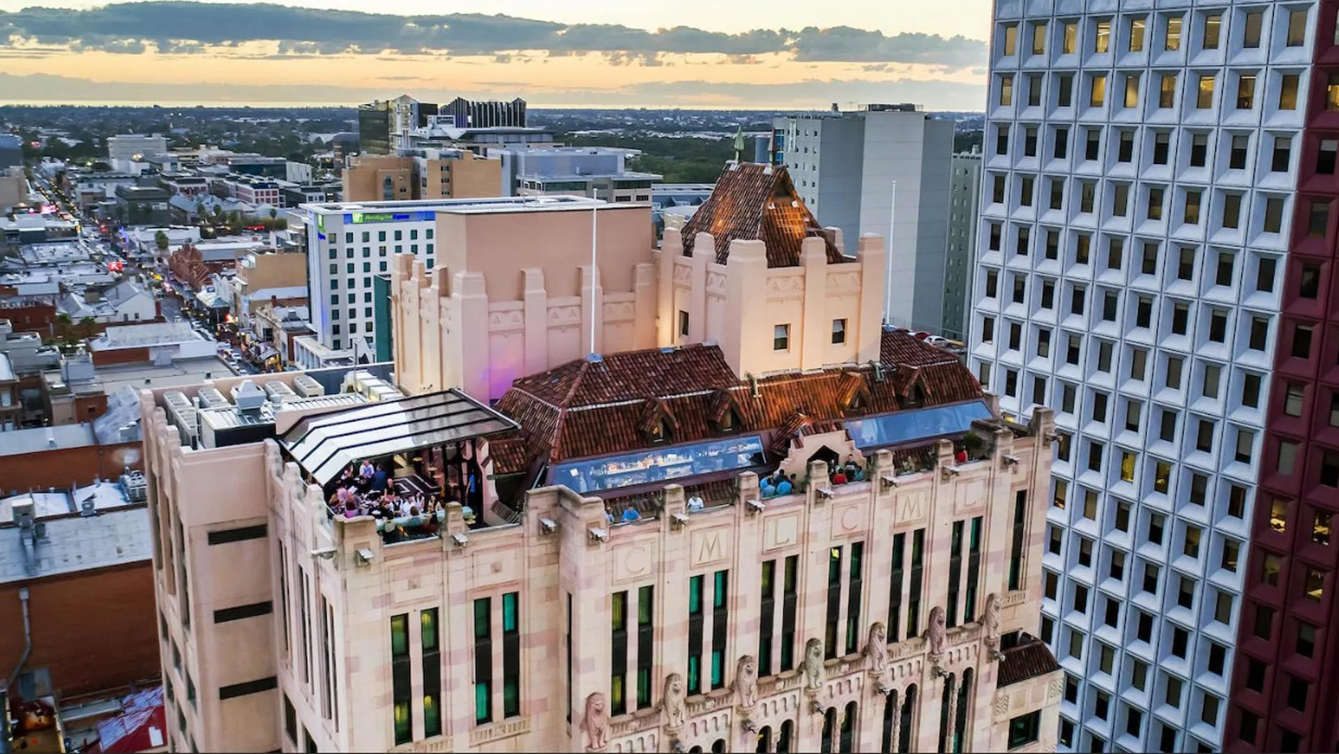 Exterior photo of Luxury Adelaide hotel The Mayfair hotel and its rooftop bar surrounded by Adelaide city buildings