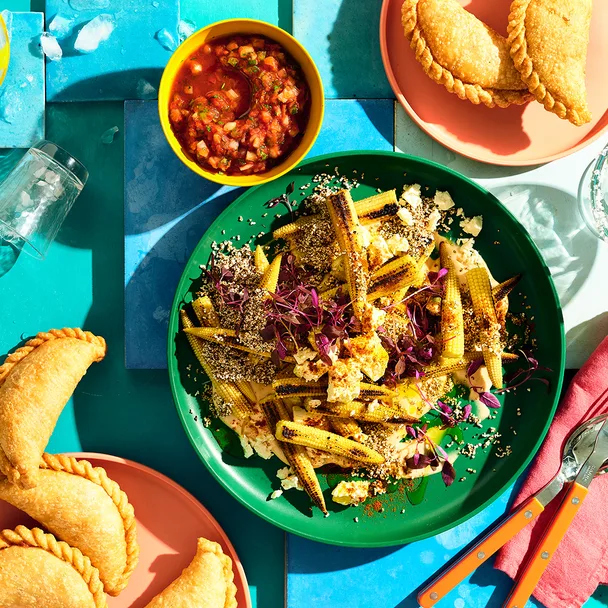 Mexican corn with amaranth and chipotle mayonnaise with empanadas to side.