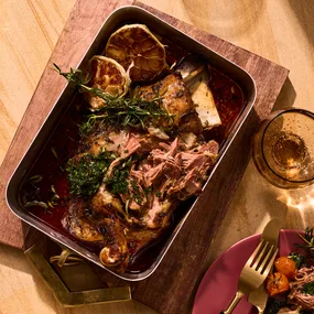 slow-cooked lamb with rosemary pesto in baking dish.