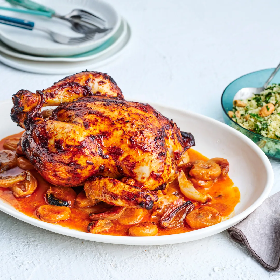 Roast apricot chicken recipe on white plate with side of almond and herbed couscous