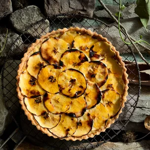 Charred apple and custard pie on wire cooling platter.