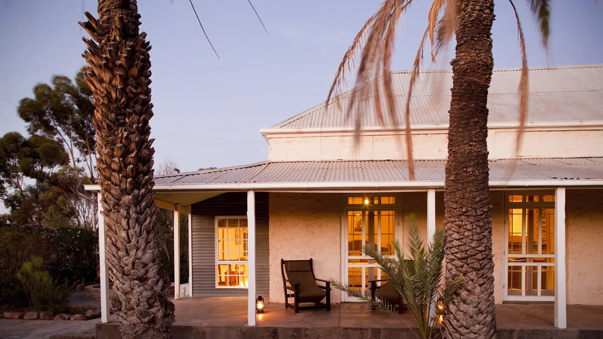 Exterior of Arkaba Homestead with large palm trees out the front