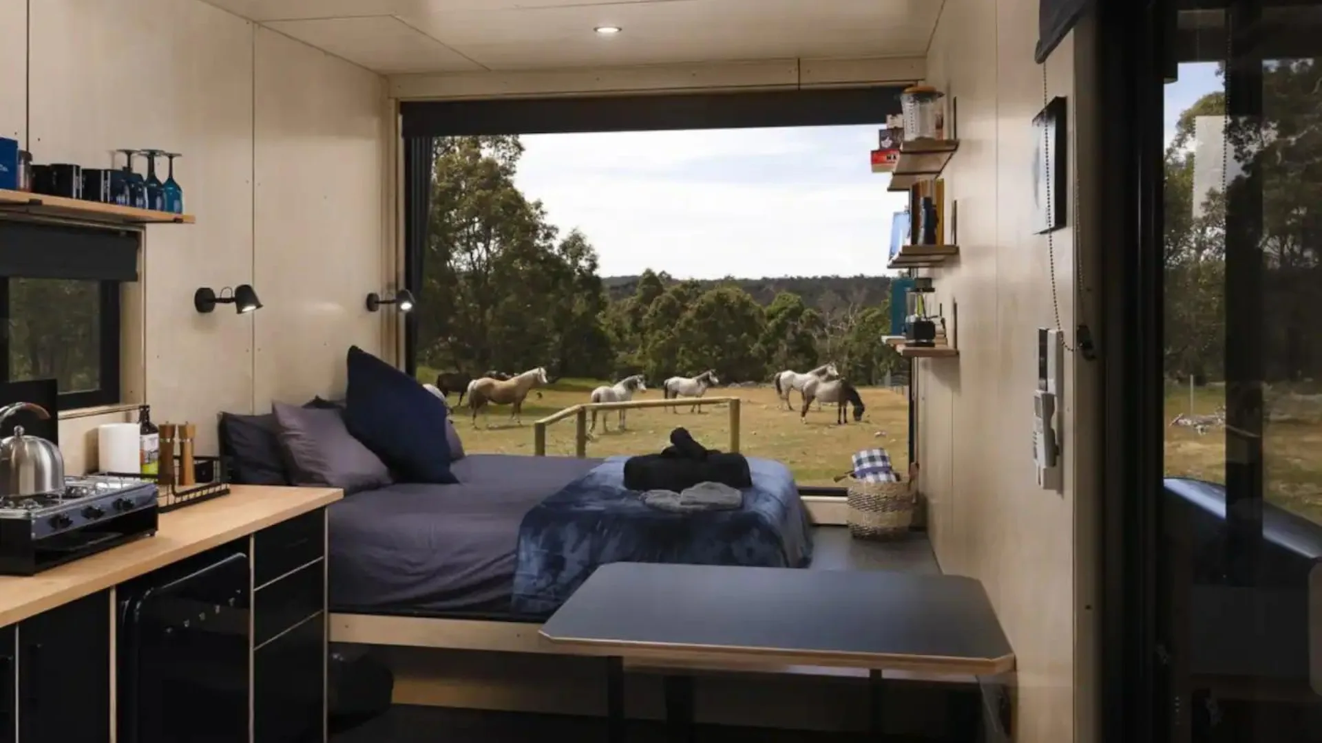 The view from the window at tiny home Heyscape Serpentine cabin in Serpentine near Perth. Horses are roaming outside,.