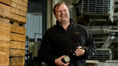 Robert Heywood holding a bottle of Clover Hill wine.