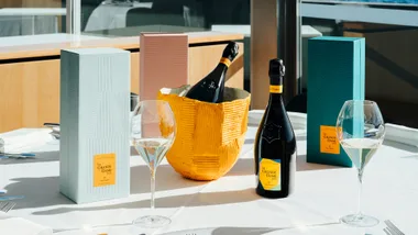 A table set with glasses and bottles of Veuve Cliquot.