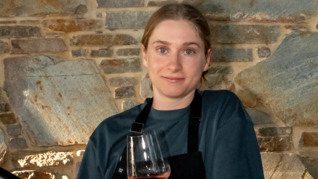 Head shot of chef Sofika Boulton holding glass of red wine