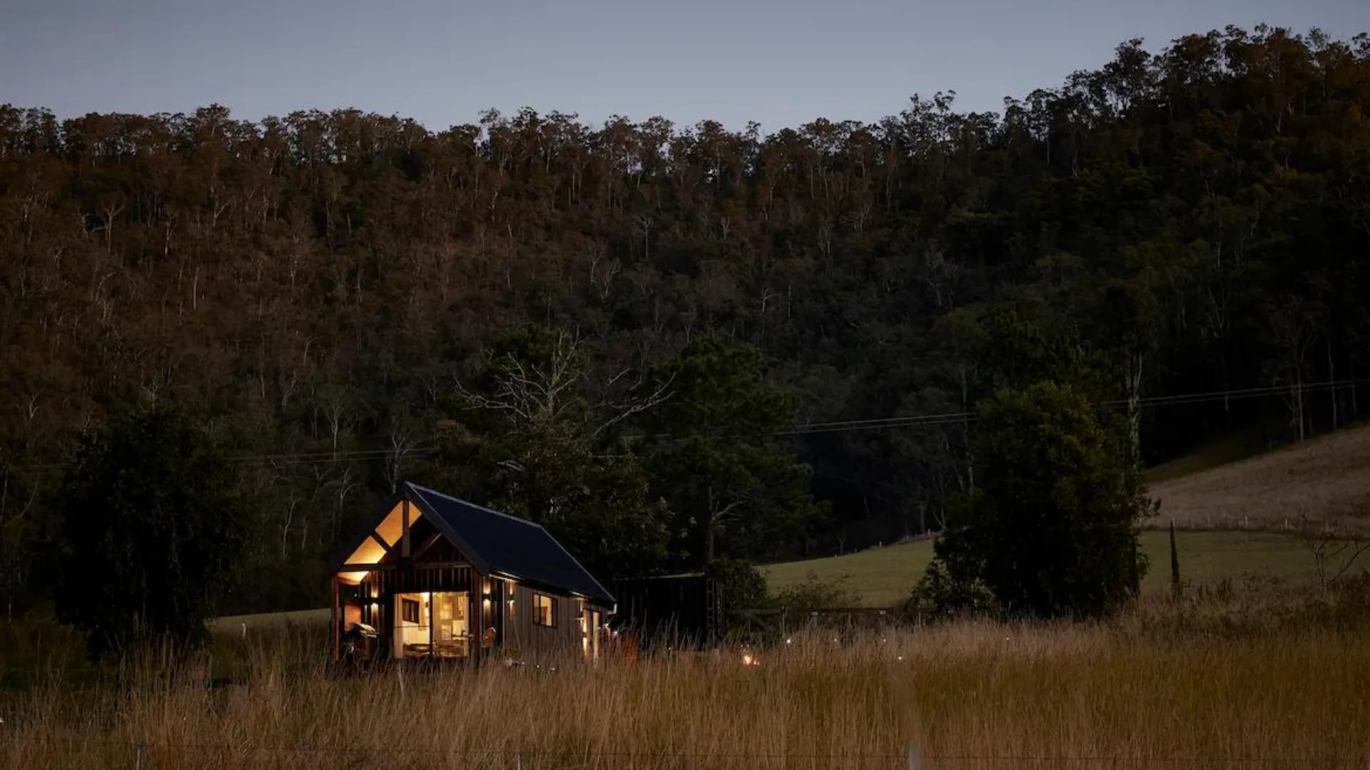 The exteriors of Misty Ridge cabin and mountainous forest views in New South Wales.