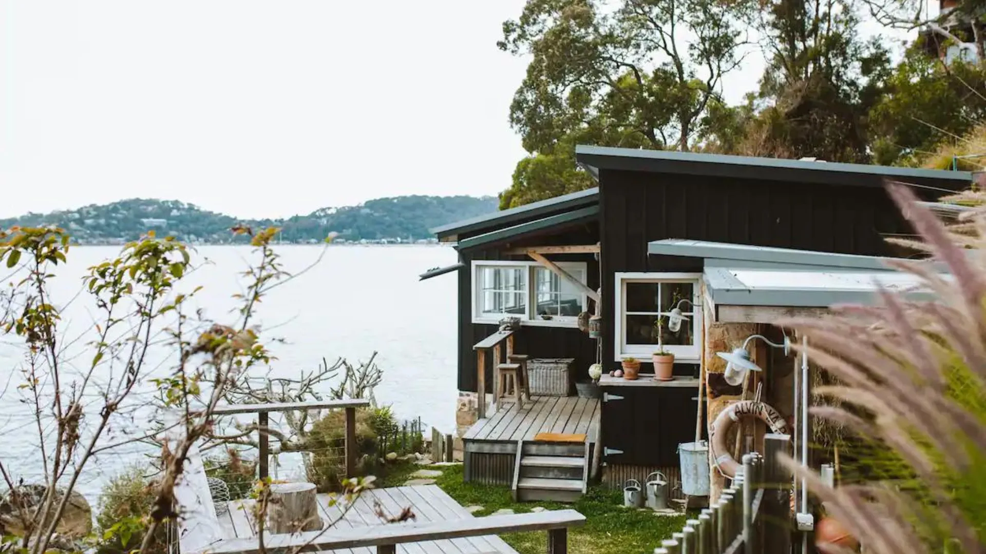 The exteriors of The Little Black Shack in Pittwater, with timber deck and view of Palm Beach.