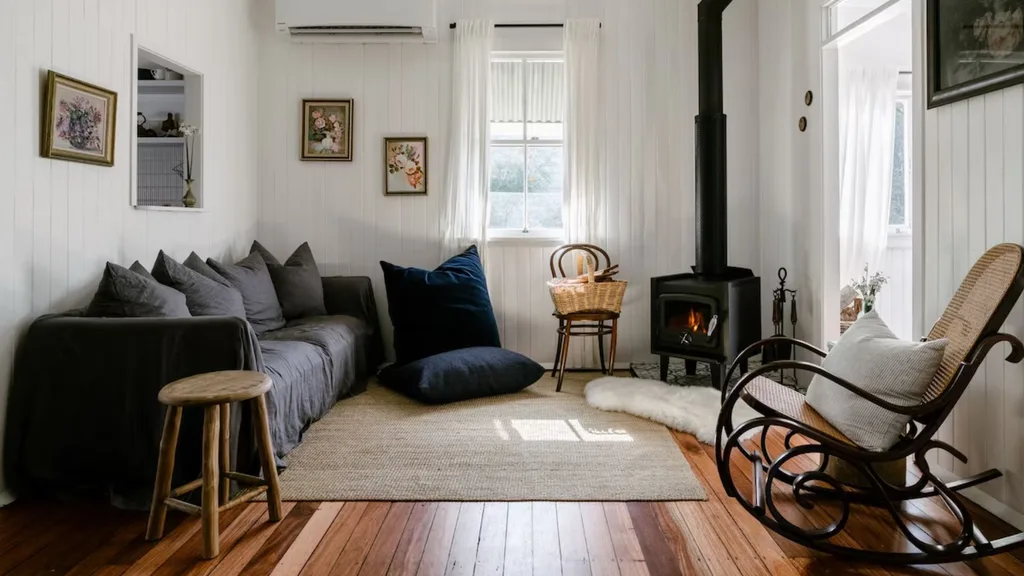 modern interior of cabin with fireplace, white walls and timber flooring