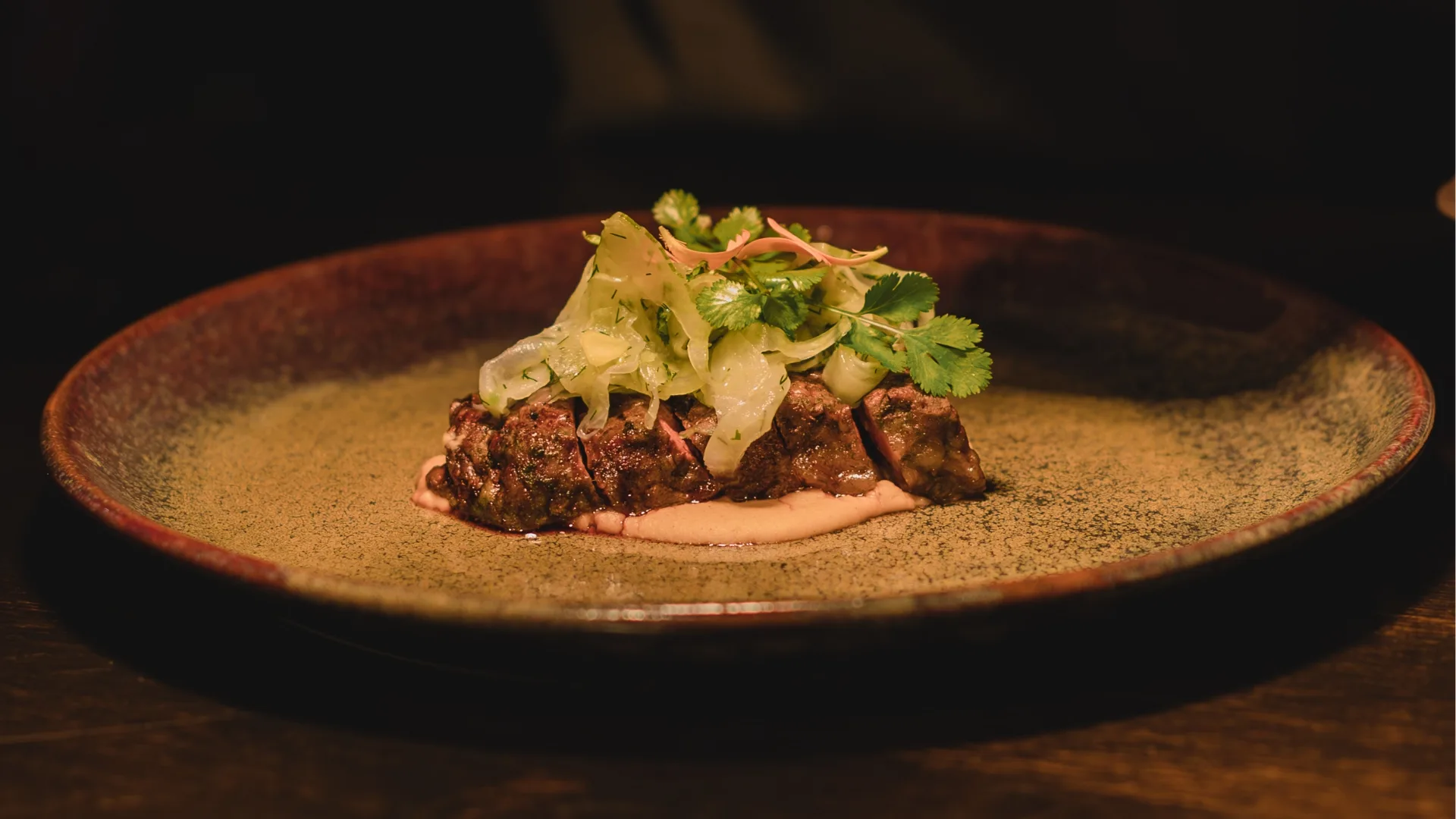 A plate with sliced steak on it.