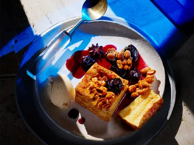 Hong Kong French toast with smoked cinnamon ice-cream and cherry with spoon on blue background.