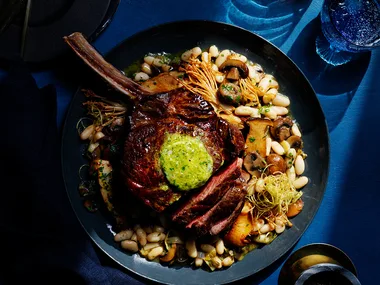 Koji rubbed steaks with whisky and miso butter on blue background.