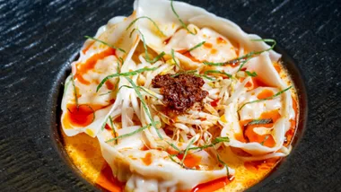 A close up picture of the laksa bombs at Ho Jiak Town Hall. Plump dumplings surrounded by a sea of coconut broth and sambal on top.