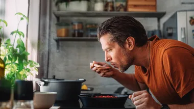 Man testing food at the hob