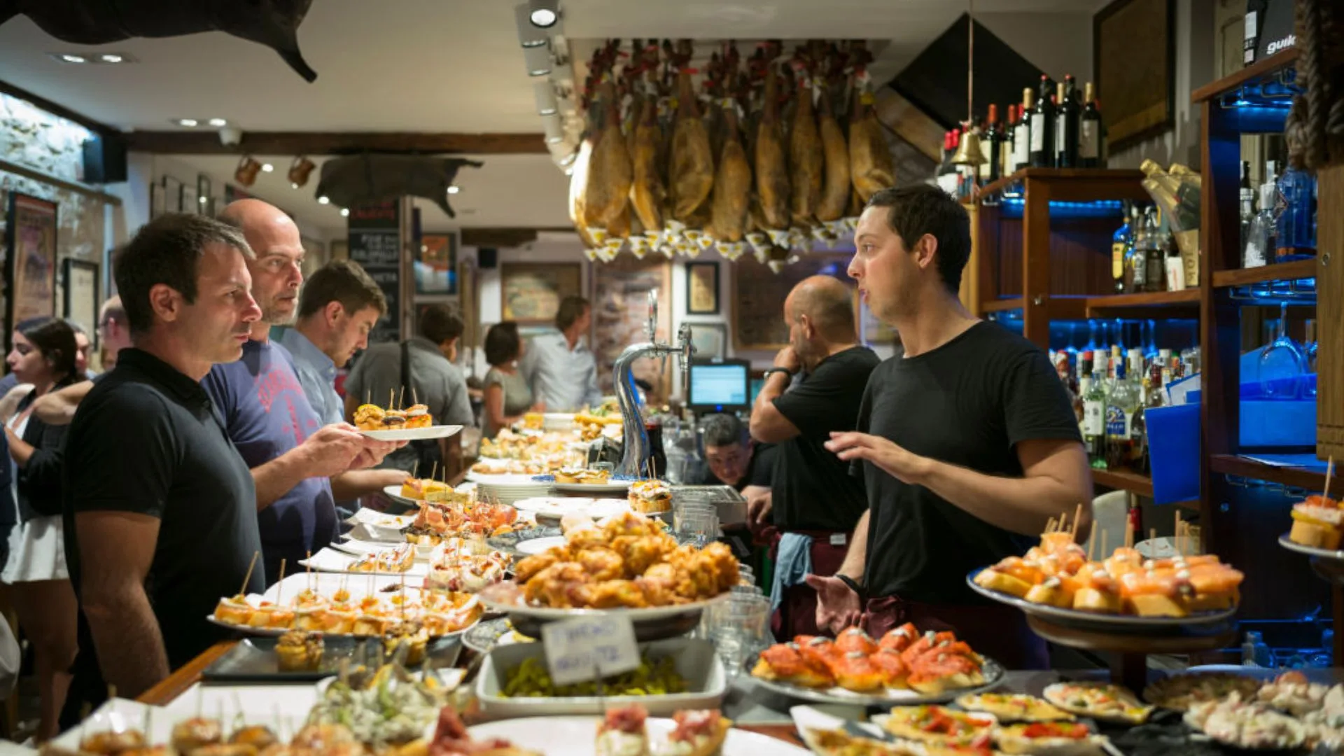 Patrons enjoying food at one of San Sebastian's pintxos bars.