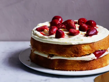 Two layer grapefruit cake with strawberries and cream