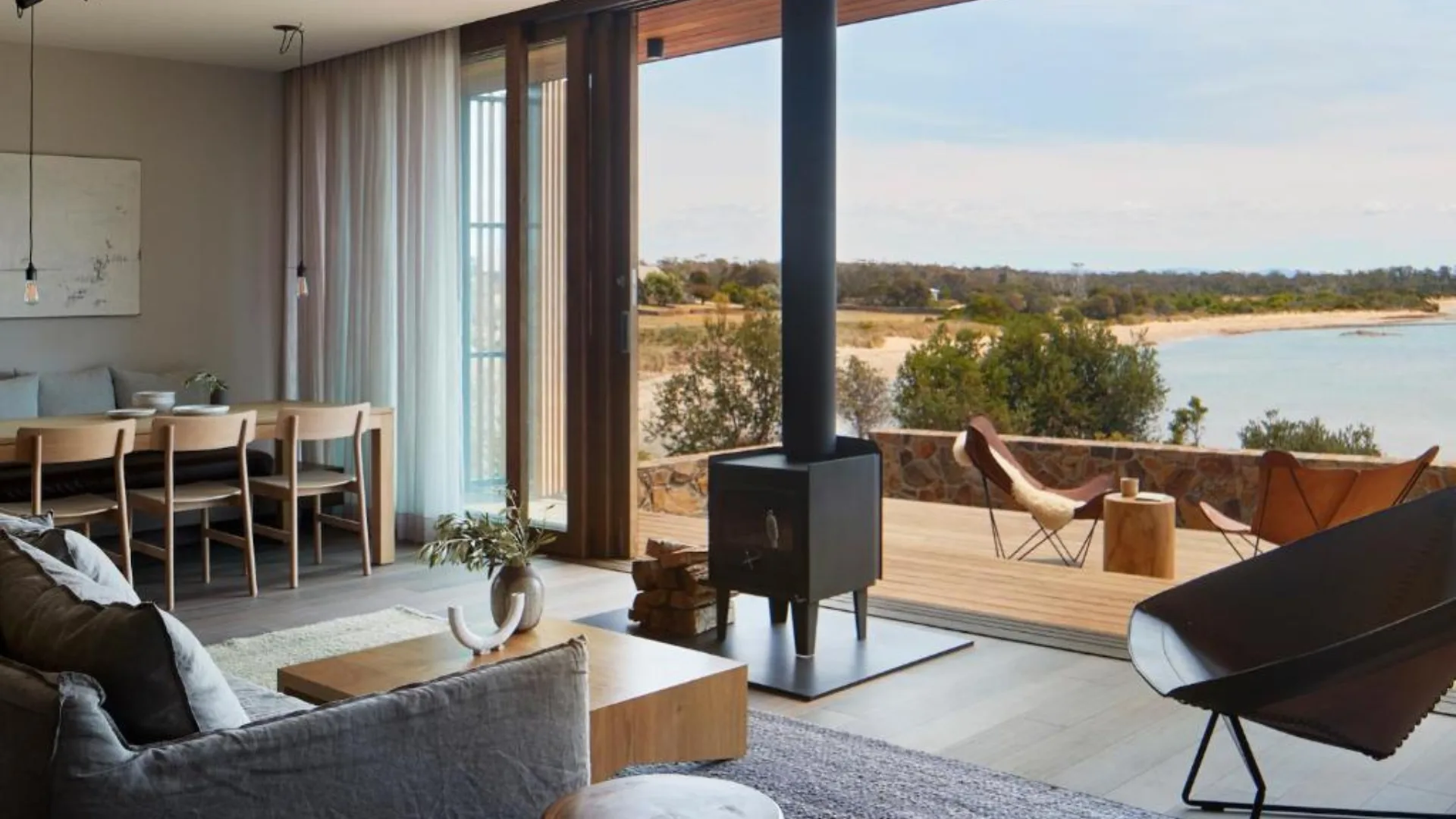 The interior living room looking out onto the bay with a fireplace at Piermont Retreat in Swansea