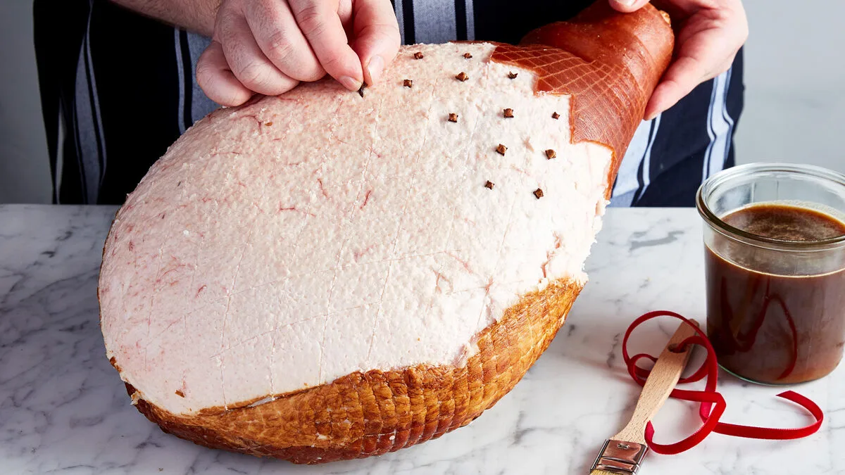 A ham being prepared with cloves and glaze from Vic's Meats