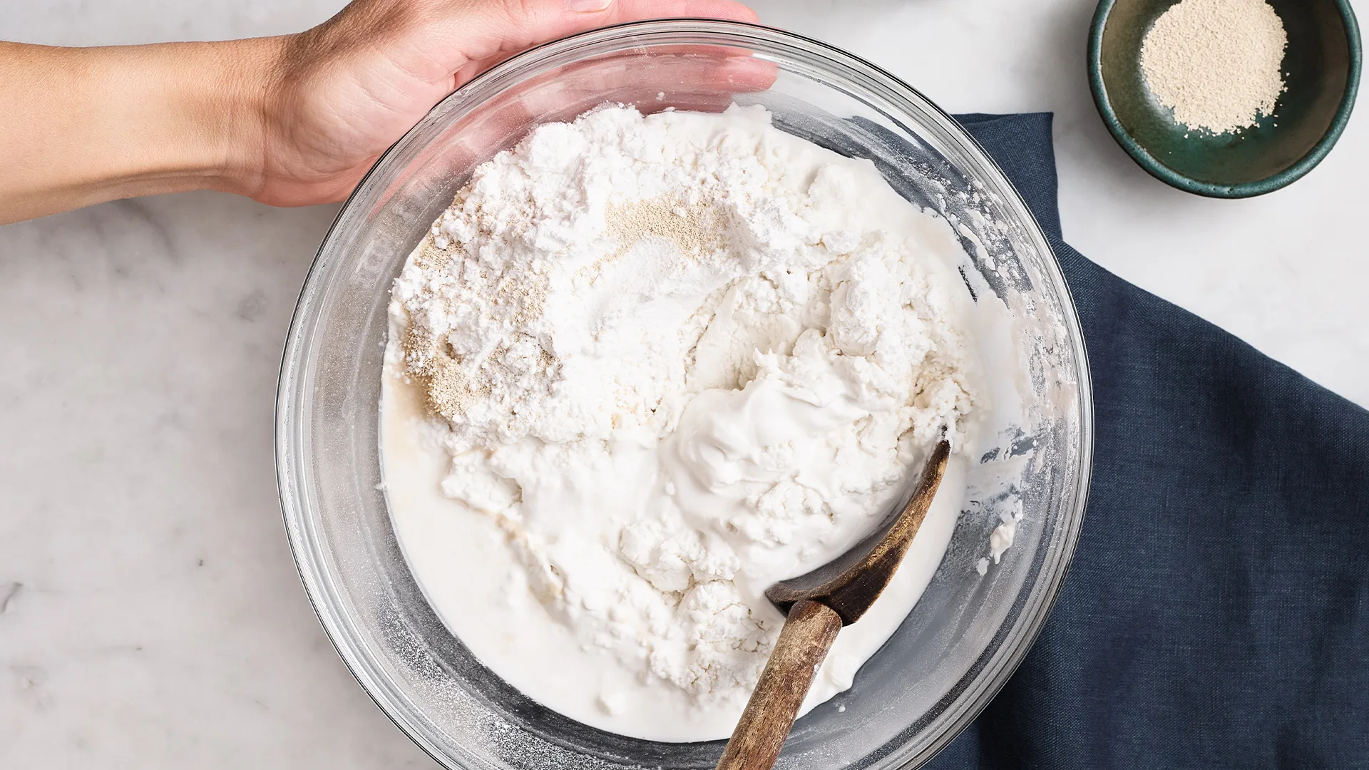 Combining rice flour and yeast with warm water to create a dough-like consistency.