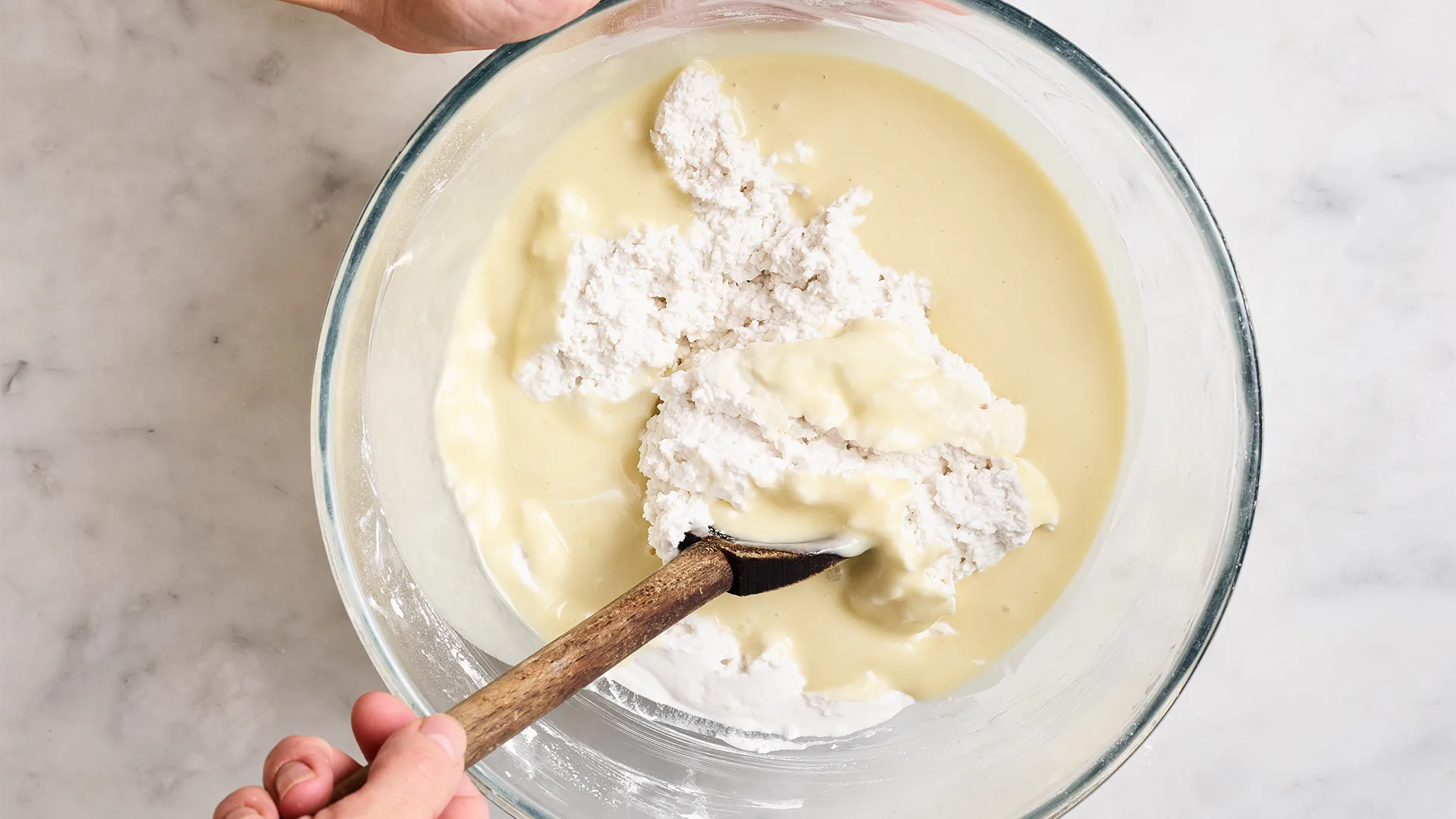 Gradually adding fermented dough to egg mixture and stirring to form a thick batter consistency.